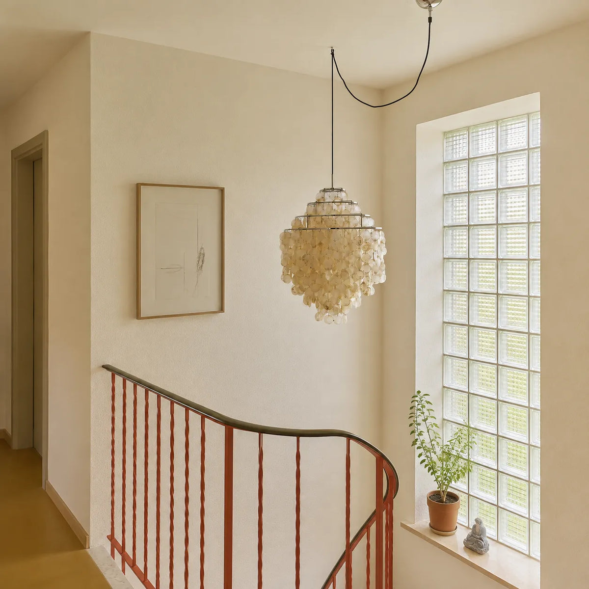 Suspension coquillage avec composition en couches de coquillages naturels et monture sculpturale en fer