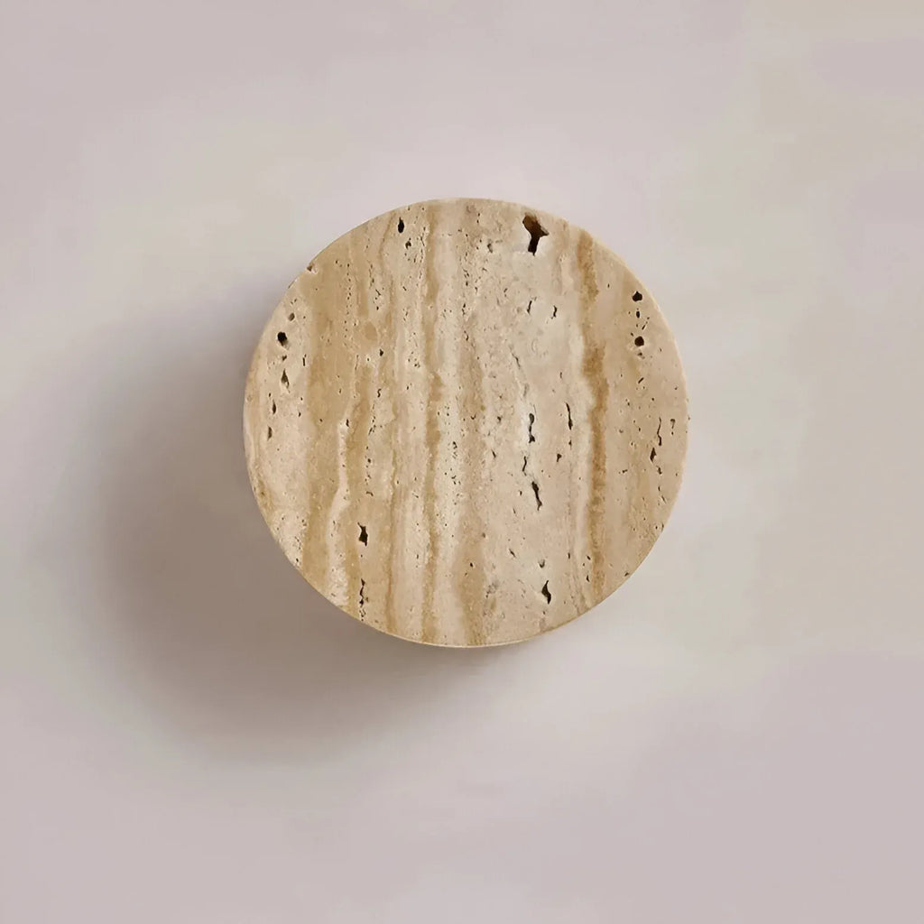 Applique murale minimaliste en travertin avec éclairage doux vers le bas et forme arrondie en pierre