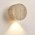 Applique murale minimaliste en travertin avec éclairage doux vers le bas et forme arrondie en pierre
