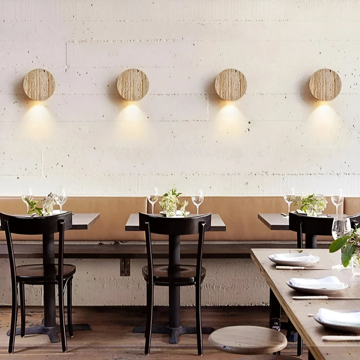Applique minimalista in travertino con luce morbida verso il basso e forma arrotondata